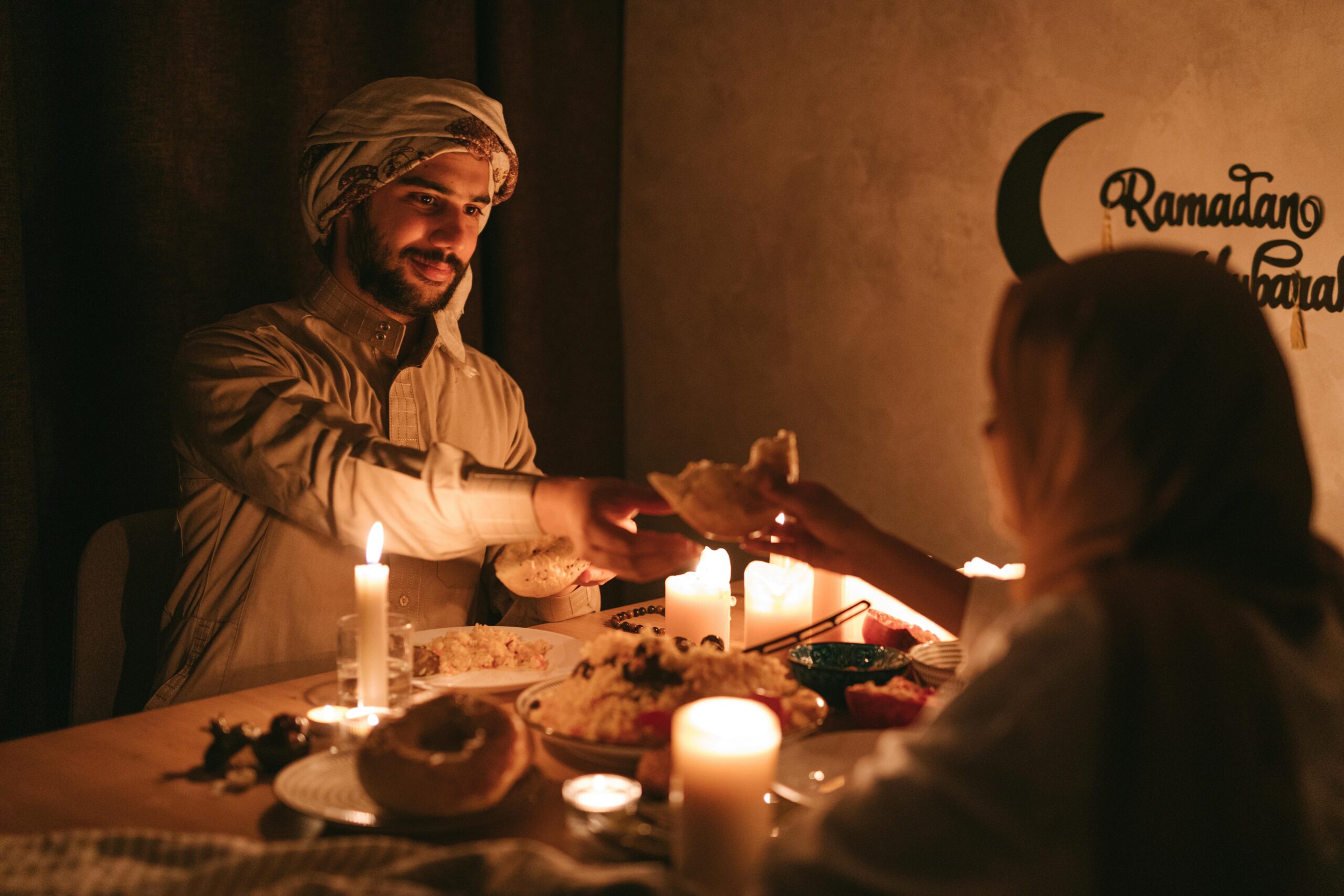 A warm, candlelit dinner during Ramadan with a Muslim family sharing a meal.